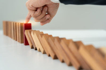 insurance with hands protect domino. Businessman hands stop dominoes falling in business crisis. business risk control and planning and strategies to run prevent insurance businesses.の写真素材