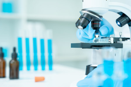 analyze biochemical samples in advanced scientific laboratory. Medical professional use microscope...