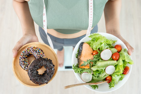 slim body Women choose during healthy foods and junk food, female choose salad for diet. Good healthy food. weight lose, balance, control, reduce fat, low calories, routines, exercise.の写真素材