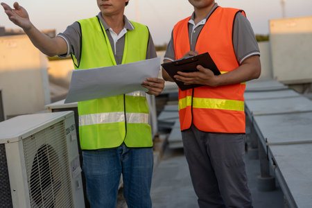Engineers use blueprint check air condition systems on site. Contractor and inspector inspection...