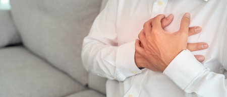 hand hold chest with heart attack symptoms, asian man working hard have chest pain caused by heart...