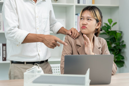 businessman sexually harassed a female colleague by touch her shoulder. Sexual harassment in office. Women feel anxious and stressed from being harassed. molest, assault, inappropriate, discriminationの写真素材