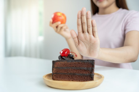 Beauty slim female body confuse chocolate cake. Woman in restaurant achieves weight loss goal for healthy life, crazy about thinness, thin waist, nutritionist. Diet, body shape.の写真素材