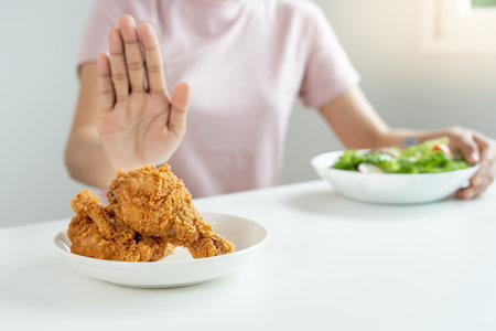 Beauty slim female body confuse fried chicken. Woman in restaurant achieves weight loss goal for healthy life, crazy about thinness, thin waist, nutritionist. Diet, body shape.の写真素材