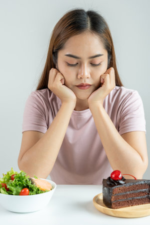 slim body asian women very bored diet food, dieting female choose low calories food for diet. Good healthy food. weight lose, balance, control, reduce fat, routines, exercise, body shapeの写真素材