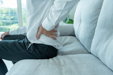 man holding her lower back while and suffer from unbearable pain health and problems, chronic back...