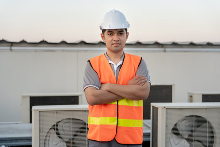 Portrait Asian maintenance engineer works on the roof of factory. contractor inspect compressor system and plans installation of air condition systems in constructionの写真素材