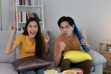 Asian young fun exultant happy fan man cheer up support sport team. crazy and happy male, man raising 2 hands very happy winner of sport, cheerful, cheer up, successの写真素材