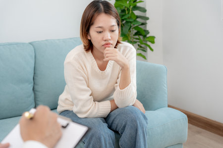 woman with mental health problems is consulting. psychiatrist is recording the patient's condition for treatment.の写真素材