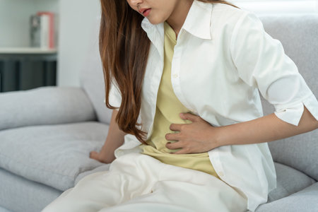 stomach ache. Asian women have abdominal pain, indigestion, gastritis, menstrual cramps, flatulence, diarrhea, distention, colon cancer, belly inflammation problemの写真素材