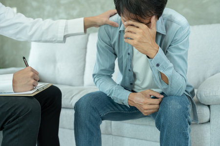 man with mental health problems is consulting. psychiatrist is recording the patient's condition for treatment.の写真素材