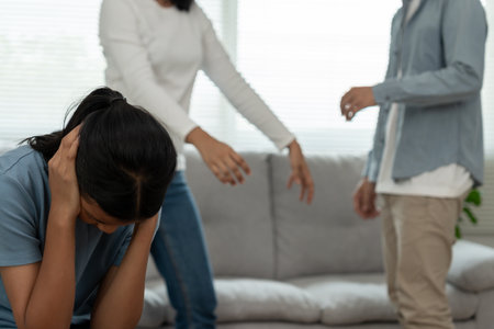 problem in family. daughter use hands cover your face and feel stressed from the parents quarrel.の写真素材