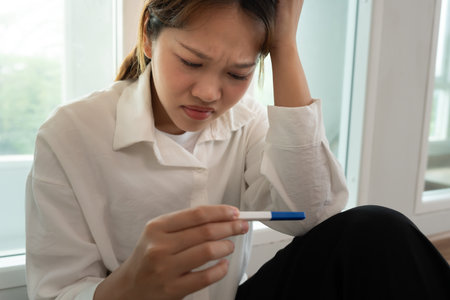 Depression and mental illness. Asian woman stressed from premarital pregnancy. Stressed girl confused with unhappy problems, arguing with boyfriend, single motherの写真素材