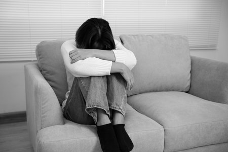 Monochrome picture, Depression and mental illness. Asian woman disappointed, sad after receiving bad news. Stressed girl confused with unhappy problems, cry and worry about unexpected pregnancy.の写真素材