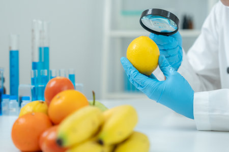 Scientist use magnifying glass to check physical occur from chemical on fruit and vegetable residues in laboratory. inspect the concentration of chemical residues,の写真素材