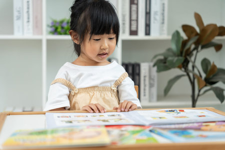 Happy Asian children relax reading books at home. Daughter and mother reading a story. Learning...