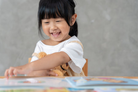 Happy Asian children relax read story book for bear doll. daughter and reading a story. learn development, childcare, education, storytelling, practice, imagine,の写真素材