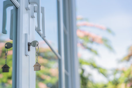 Landlord key for unlocking house is plugged into the door. Second hand house for rent and sale. keychain is blowing in the wind. mortgage for new home, buy, sell, renovate,の写真素材