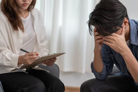 man with mental health problems is consulting. psychiatrist is recording the patient's condition for treatment.の写真素材