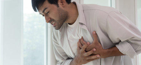 hand hold chest with heart attack symptoms, asian man have chest pain caused by heart disease