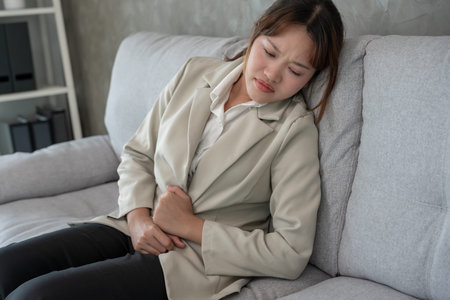 Business woman have stomach ache. Stomach ache due to eating irregularly, menstrual cramps,...