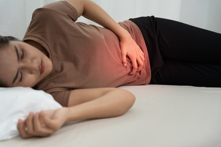 stomach ache. Asian women have abdominal pain, indigestion, gastritis, menstrual cramps, flatulence, diarrhea, distention, colon cancer, belly inflammation problemの写真素材