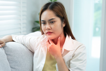 woman put on neck due to a sore throat. female tonsillitis causes a inflammation. treated by taking...