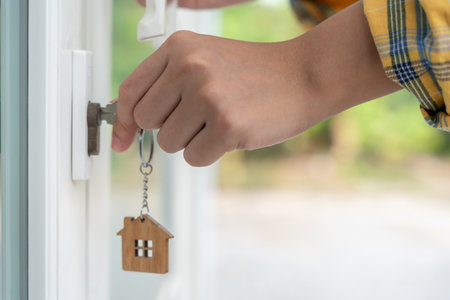 Key for unlocking house is plugged into the door. Second hand house for rent and sale. Hand unlock door for new home, buy, sell, renovate, investmentの写真素材