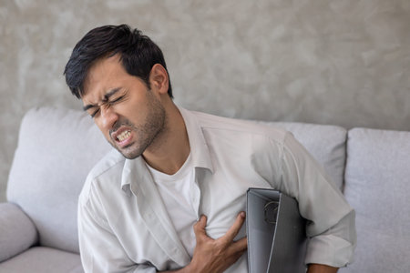 hand hold chest with heart attack symptoms,  man working hard have chest pain caused by heart...