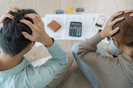 Stressed and headache asian couple with large bills or invoices no money to pay to expenses and credit card debt. shortage, Financial problems, mortgage, loan, bankruptcy,の写真素材