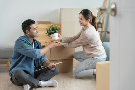 Moving house, relocation. Couple help set and move furniture for new apartment, inside the room was...
