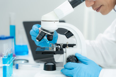 Scientist analyze biochemical samples in advanced scientific laboratory. Medical professional use microscope look microbiological developmental of viral.の写真素材