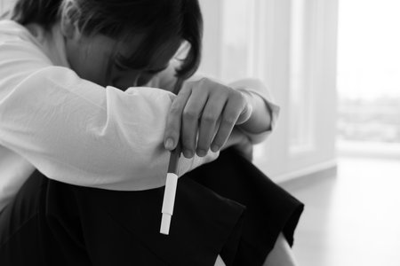 Depression and mental illness. Asian woman stressed from premarital pregnancy. Stressed girl confused with unhappy problems, arguing with boyfriend, single mother, social problemsの写真素材