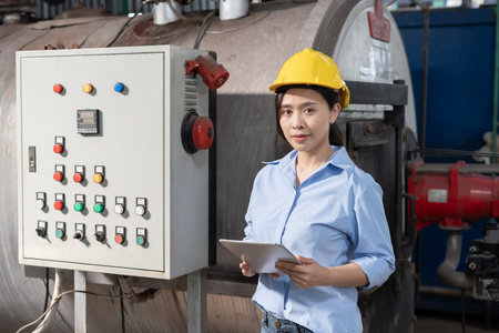 portrait Engineers or factory managers wearing safety helmet inspect the machines in the production line. The inspector opened the machine to test the system to meet the standard.の写真素材