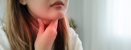 Asian woman put on neck due to a sore throat. female tonsillitis causes a inflammation. treated by...