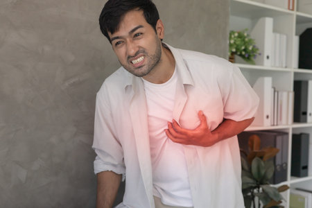 hand hold chest with heart attack symptoms, asian man working hard have chest pain caused by heart...