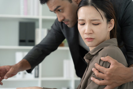 Manager or senior sexually harassed a female colleague by touch her shoulder. Sexual harassment in office. feel anxious and stressed from being harassed. molest, assault, inappropriate, discriminationの写真素材