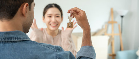 Moving house, relocation. Husband show key new condominium or house for husband, inside the room was a cardboard box containing personal belongings and furniture.の写真素材