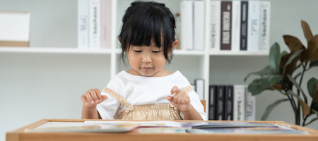 Happy Asian children relax read book at home. daughter and reading a story. learn development, childcare, laughing, education, storytelling, practice, imagine,の写真素材