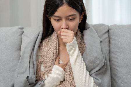 sick woman with a headache sitting under blanket, female sneezing and runny nose with seasonal influenza, allergic, high fever and influenza, resting, virus, coronavirus,の写真素材
