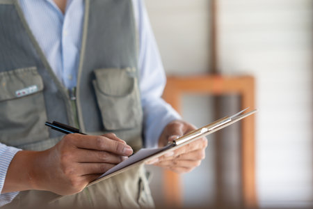 inspector or engineer is inspecting construction and quality assurance new house using a checklist. Engineers or architects or contactor work to build the houseの写真素材