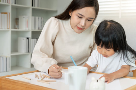 Happy Asia mother playing learning paint for little girl. Funny family is happy and excited in the house. Mother and daughter  having fun spending time together. Holiday, Activityの写真素材