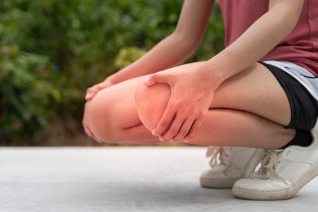 Woman athlete having knee injury due to ligament inflammation, knee pain due to exercise, massage,...