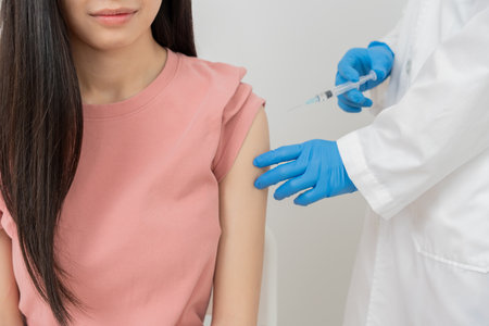woman getting a vaccination to prevent pandemic. receive a dose of immunization virus vaccine from a nurse or doctor at the medical center, basic vaccine, alternative vaccineの写真素材