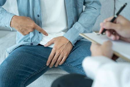 Man point on in front of private parts feeling discomfort from disease and inflammation. Venereal, testicular cancer. bladder problems, erectile dysfunction, premature ejaculation,の写真素材