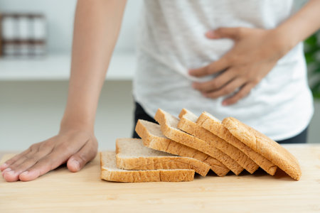 Wheat allergy, gluten allergy, women refuse to eat bread, swollen mouth, swollen eyes, itchy rash, hives, stuffy nose, difficult breathing, itchy eyes, stomach pain, nausea,の写真素材
