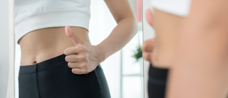 Women showing results of diet. Beautiful shape. female look mirror for check shape body have a reduced waist size after under going a weight loss corse. balance, controlの写真素材