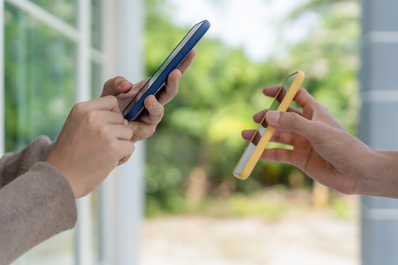 Happy Asian woman scan QR code for pay goods delivery. Delivery man send deliver express. online shop, paper container, takeaway, postman, delivery service, packagesの写真素材