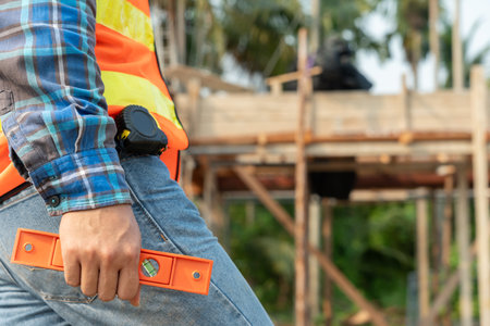 Contactor or engineer is inspecting construction and quality assurance new house using a level. Engineers or architects or contactor work to build the houseの写真素材