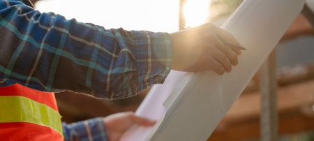 inspector or engineer is inspecting construction and quality assurance new house using a blue print. Engineer or architects or contactor work to build the houseの写真素材